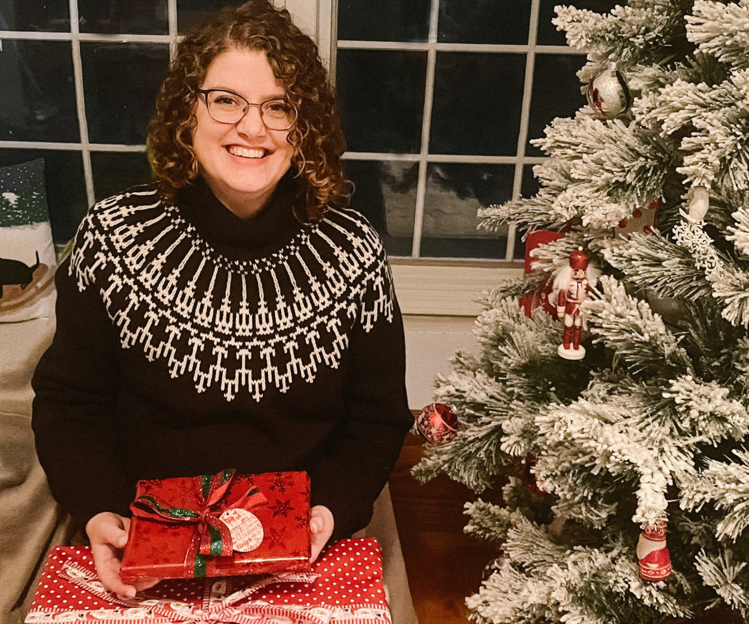 Person with presents by a Christmas tree