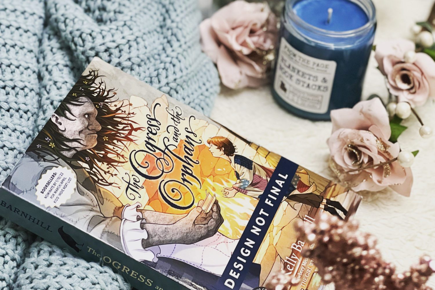 Book cover of Ogress and the orphans with a sweater and a candle