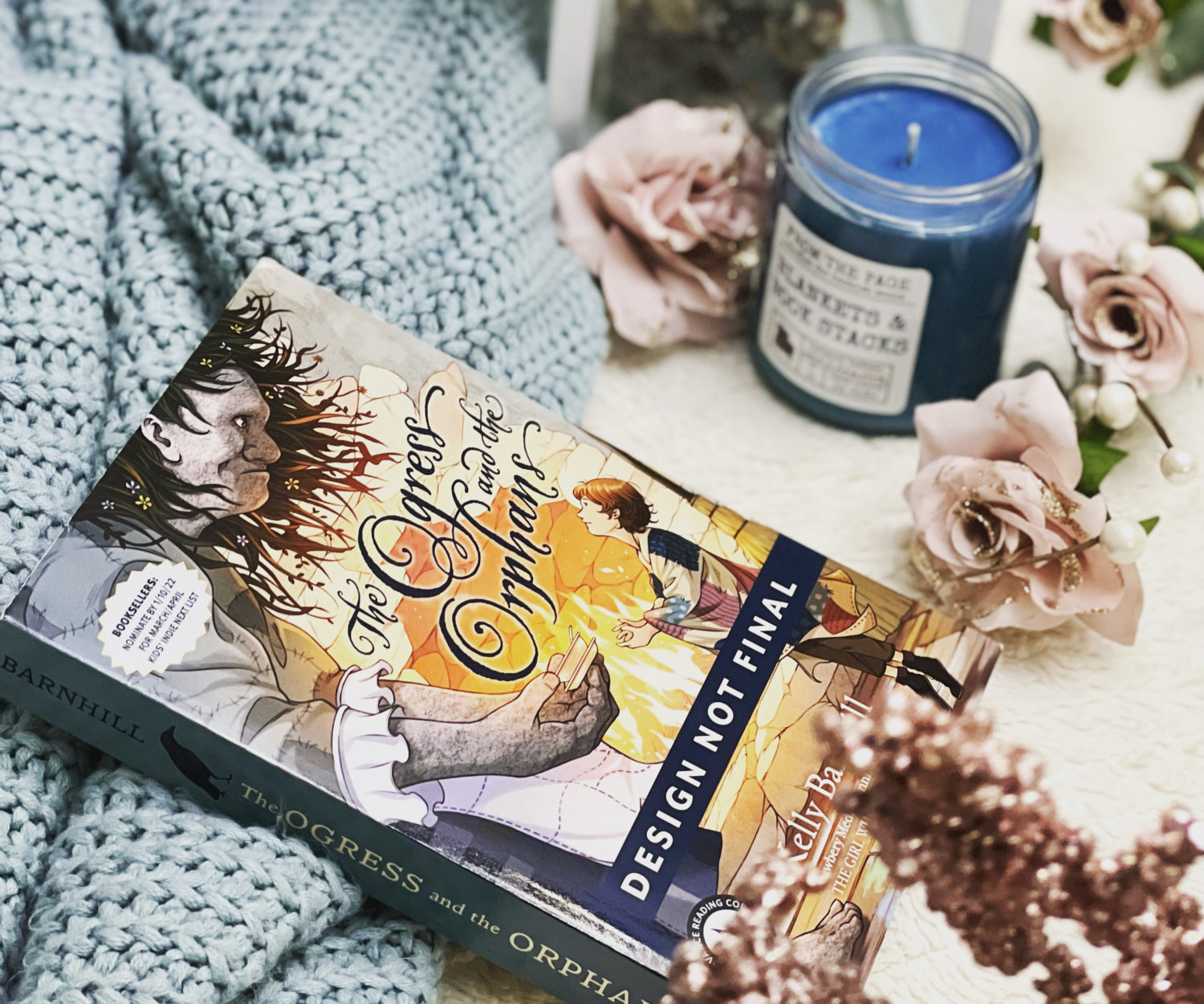 Book cover of Ogress and the orphans with a sweater and a candle