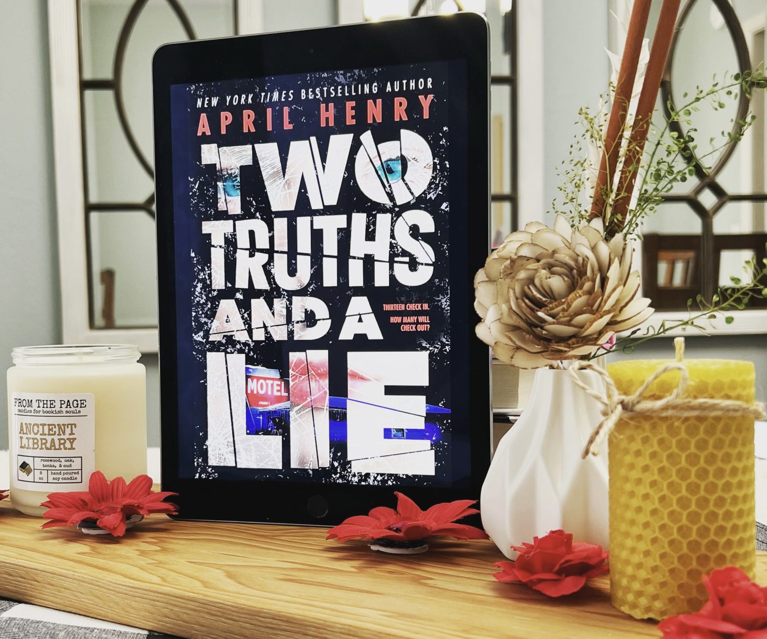 Book Cover of Two Truths and a Lie with flowers and a candle